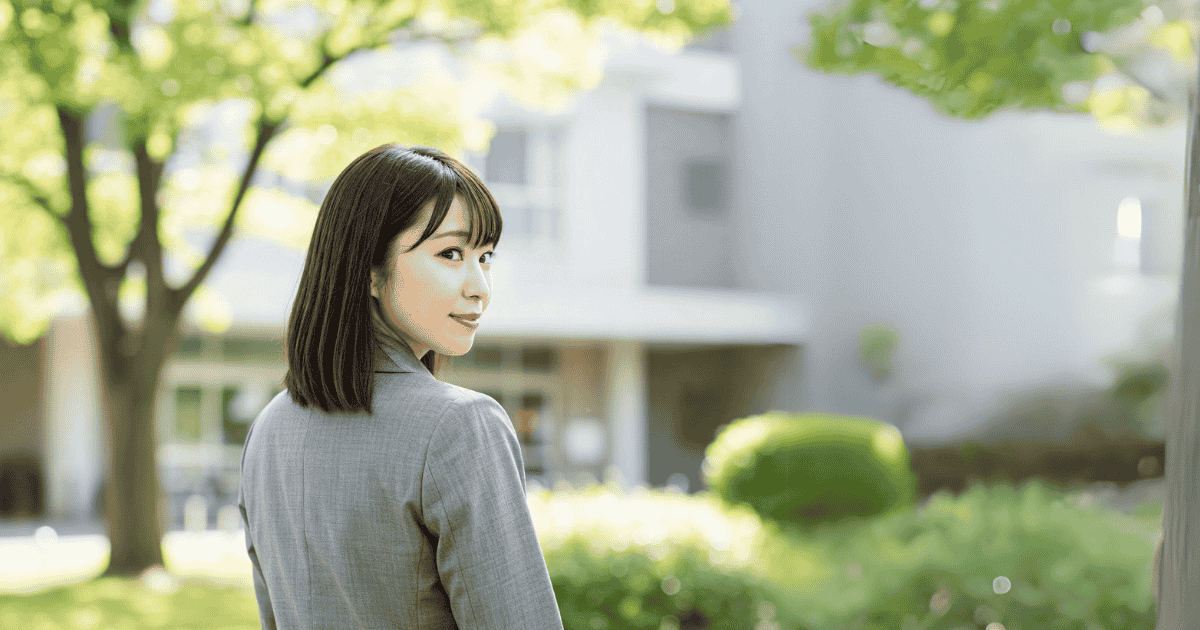新緑、スーツの女性、振り返り